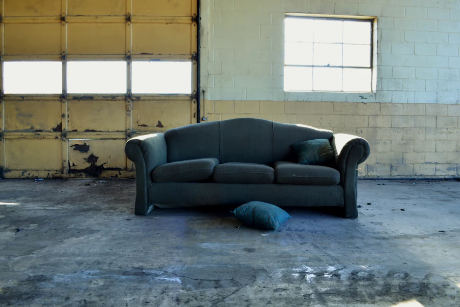 Old sofa set out by a garage door for removal